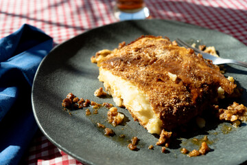 A slice of homemade shephard's pie served on a plate on a rustic table