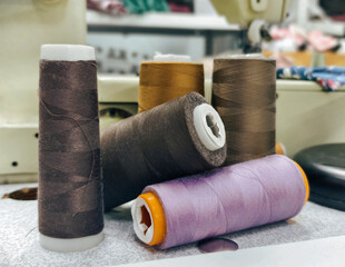 Close-up of colorful thread spools on a sewing table
