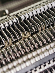A closeup of a working knitting machine demonstrating industrial knitting production