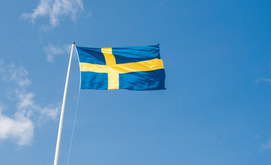 Swedish national flag blue yellow against the sky