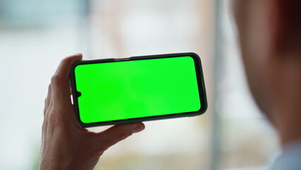 Entrepreneur holding horizontal mockup cellphone at office closeup. Unknown man