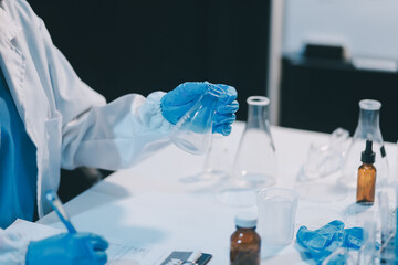 Fototapeta premium Research, experiment and medical trial being done by a scientist in a lab, science facility or hospital. One young, serious and professional researcher organizing, sorting or making a discovery