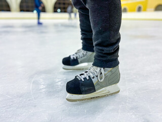 Ice skater wearing modern ice skates on ice rink surface