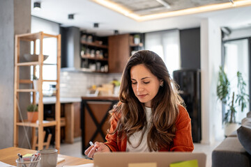 Focused female freelancer working from home office