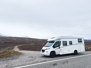 Exploring the nordic landscapes: a white camper van on a scenic road in norway, heading towards the...