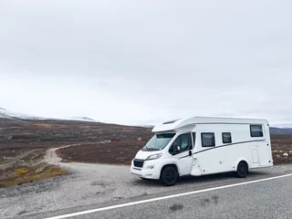 Fotobehang Exploring the nordic landscapes: a white camper van on a scenic road in norway, heading towards the arctic circle for an adventurous journey © Alberto Gonzalez 