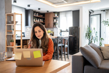 Focused freelancer working remotely from home office using laptop