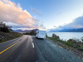 A motorhome parked by the road in the autumn landscape of the Lyngen Alps, Northern Norway, with mountains.
