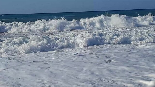 footage of foaming waves crashing noisily on a sandy beach on the island of Crete in Greece in august 2023