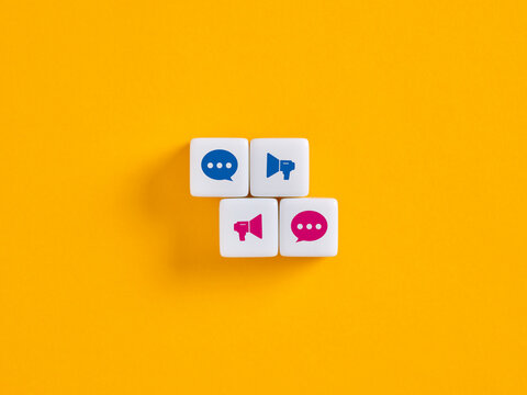 Social media marketing concept with megaphone and speech bubble icons on dice over yellow background - Powered by Adobe