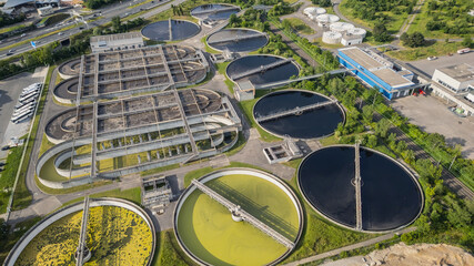 Eco-friendly aerial view of wastewater treatment plant near Lyon, France, with urban skyline –...