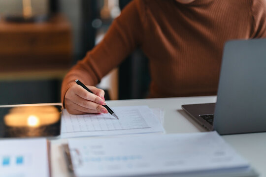 Asian female accountant working with tax financial statement at home