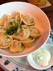 Vietnam, Nha Trang - 15.06.2025 - Russian cuisine, pelmeni with sour cream and herbs. Vareniki with potatoes, and pelmeni with meat. The most delicious food. Dough and meat with beyon in cafe, home fo