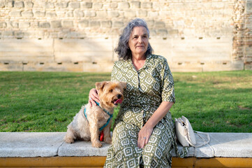 Portrait of a mature woman with her dog in the park