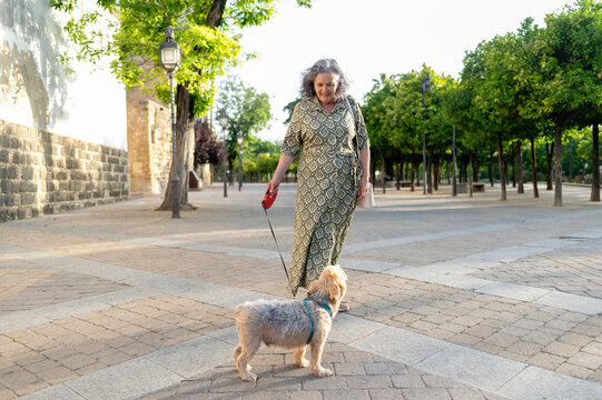 Mature woman playing with her dog outdoors