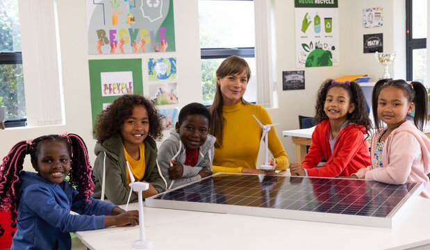In school, female teacher and diverse students learning renewable energy in eco-friendly classroom