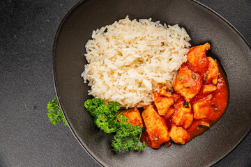 Chicken curry rice butter chicken tikka masala spicy meat bowl on the table fresh tasty gourmet food background on rustic food top view copy space