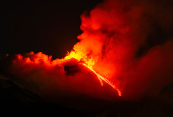 eruption of volcano during night ,  Night sky fire explosion burst flame smoke burning light glow hot. Erupting volcano Etna in Sicily, Italy. © Yaroslav