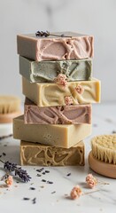 Stack of Artisan Soaps with Dried Flowers and Brush on White Marble