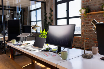 Modern office desk with laptops and charts, ready for coding and analysis, copy space