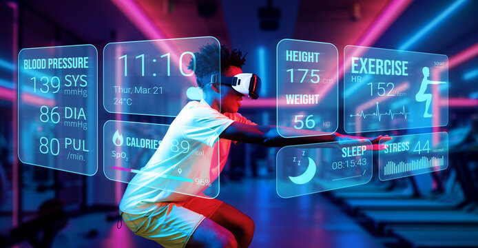 African man wearing shirt and VR headset while exercising at futuristic gym with glowing blue and red. Happy male model doing squat and looking at hologram. Augmented reality technology. Ingenuity.