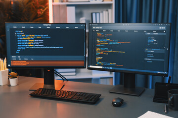 Programming code on computer two screens on desktop placing working desk showing intelligent...
