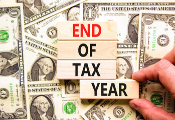 End of tax year symbol. Concept words phrase End of tax year on beautiful wooden blocks. Dollar...
