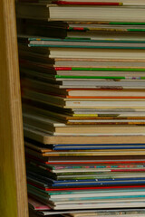 An image depicts an arrangement of books skillfully stacked on a shelf, highlighting a variety of covers and sizes, which is characteristic of a cozy home or a serene library environment