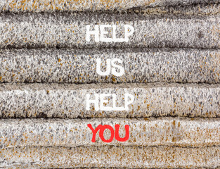 Help you symbol. Concept words phrase Help us help you on beautiful grey stone wall. Beautiful...