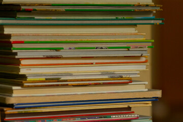 A tall stack of diverse books organized vertically on a shelf, proudly displaying an array of...