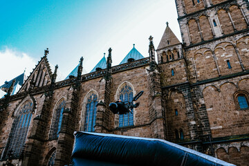 BMX rider backflipping in front of Gothic cathedral facade