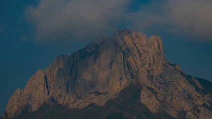 Majestic mountain peak bathed in twilight sky with clouds shimmering above