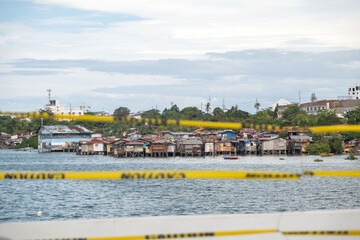 Stilt houses line the water's edge in Cebu City, showcasing the resilience of residents who navigate daily life in challenging conditions. The setting reflects both beauty and hardship.