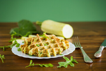 Vegetable zucchini waffles with herbs on a wooden table
