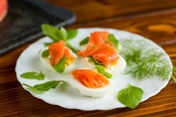 Portioned appetizer with egg halves and salmon on a plate