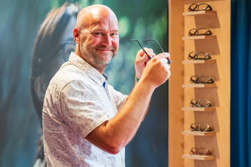 Happy man with bald head and sun glasses at shop 