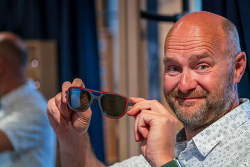 Happy man with bald head and sun glasses at shop 