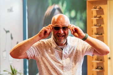 Happy man with bald head and sun glasses at shop 