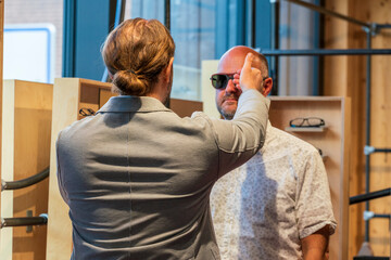 Happy man with bald head and sun glasses at shop 