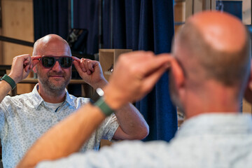 Happy man with bald head and sun glasses at shop 