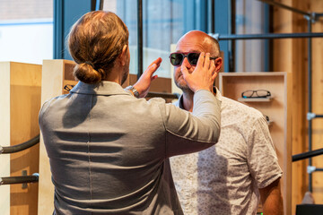 Happy man with bald head and sun glasses at shop 