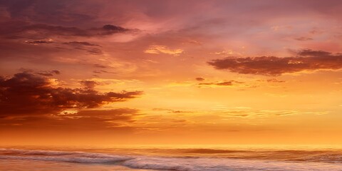 Obraz premium Dramatic sunset over the ocean with orange and purple clouds reflecting on the water surface below view