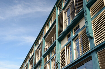Modern building exterior with glass and teal accents under clear blue sky