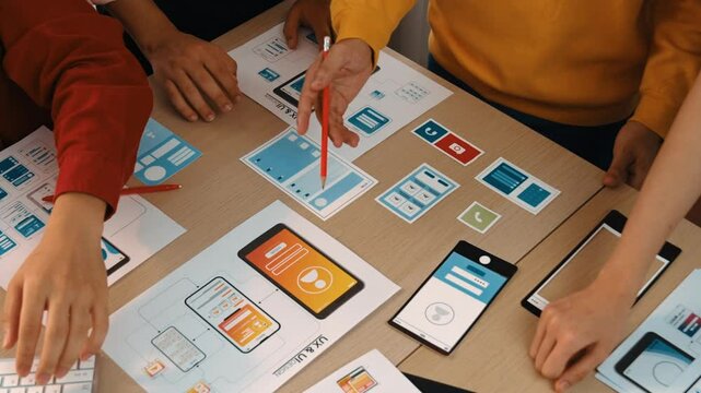 Smart startup company employee group planning on user interface prototype for mobile application or website in office. Clever UX UI designer brainstorm designing user friendly interface plan. Synergic