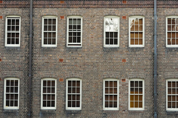 Symmetrical historic brick facade with nine white-framed windows