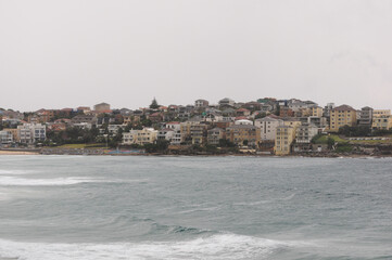 Overcast view of coastal homes along the rocky shores of Sydney's iconic beach.
