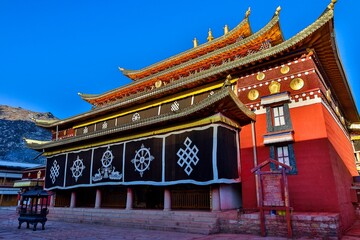 Traditional Tibetan architecture of Taktsang Lhamo Monastery (Langmusi), a prominent Buddhist monastery in the Amdo region, showcasing vibrant colors and ornate details.