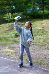 Young girl playing with frisbee in a lush green park environment