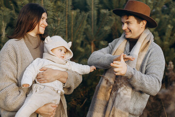 Happy family having fun with cute baby son in autumn woods in soft evening light. Parenthood....