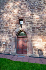 Heavy Gothic cathedral door with stone arch and stained glass